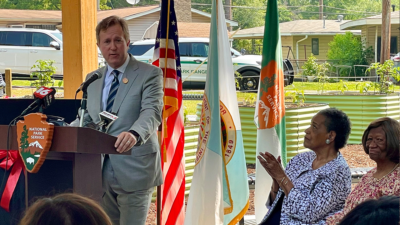 Myrlie Evers and others look on as Haley Fisackerly speaks at the grand opening dedicating the Evers' home as a National Monument.